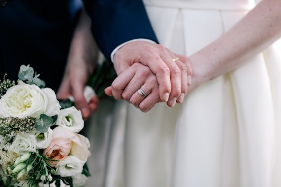 手をつなぐ結婚式のカップル